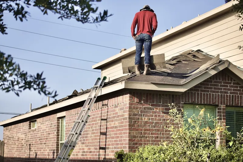 Professional roofer working on a residential roof in Madley